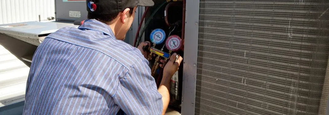 HVAC technician servicing a condenser unit in Mokena