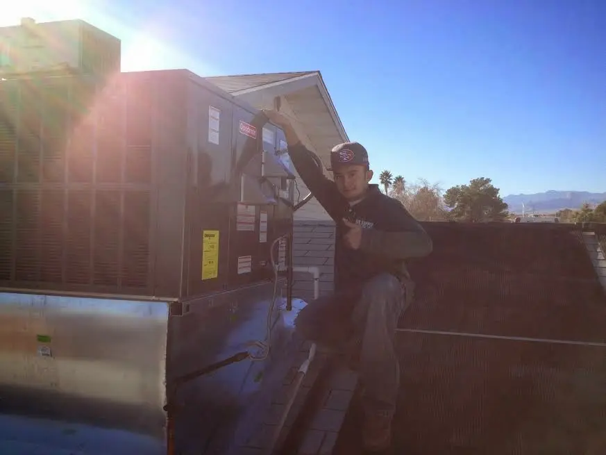 HVAC technician performing HVAC Inspection on a rooftop unit in Mokena